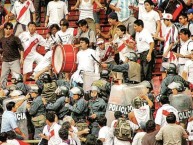 Foto: "La banda enfrentando a los tombos debido a la reprensión policial en el viejo estadio nacional" Barra: La Banda del Basurero • Club: Deportivo Municipal